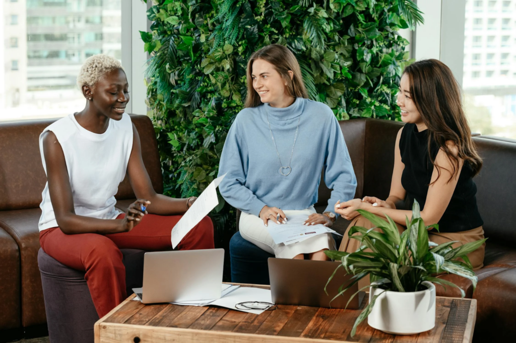 Photo de trois femmes assise sur un canapé. Elle travaillent ensemble.